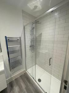 W łazience znajduje się prysznic ze szklanymi drzwiami. w obiekcie Stunning 1 bed central flat w mieście Woking
