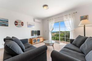 a living room with two couches and a large window at Paz e Vista Mar with Pool & WiFi in Luz