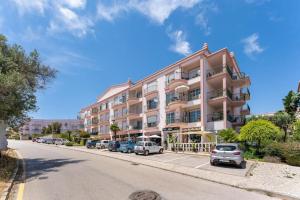 a large building with cars parked in a parking lot at Paz e Vista Mar with Pool & WiFi in Luz