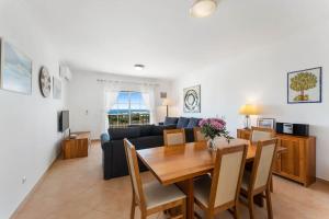 a dining room and living room with a table and a couch at Paz e Vista Mar with Pool & WiFi in Luz