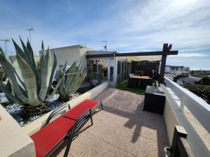 een rode bank bovenop een patio bij Villa Bellevue Port Nature3 Village Naturiste 2 chambres in Cap d'Agde