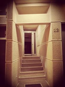 un couloir avec des escaliers menant à une porte dans l'établissement Temple Apartments Belgrade, à Belgrade