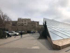 un hombre parado frente a un edificio con techo de cristal en Caspian Hostel, en Baku