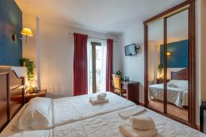 a bedroom with a large white bed and a mirror at I AM La Posada Hotel and Apartment in Benalmádena