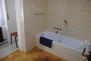 a bathroom with a bath tub with a blue towel at Appartamento da Bruna e Manuela in Tenno