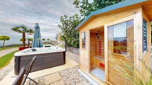 Villa Four Stars ART-PE في Trebnje: مبنى خشبي صغير مع حوض استحمام ساخن فيه