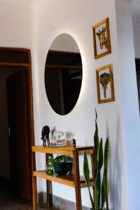 Cette chambre comprend un miroir et une table avec une plante. dans l'établissement Goodtimewithfar House, à Moshi