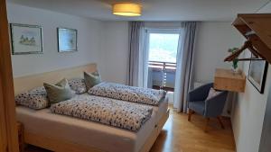 a bedroom with a bed and a chair and a window at Ferienwohnung Pia in Wald am Arlberg +30 photos