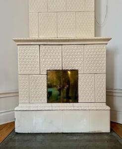 a white brick fireplace with a mirror on it at Lägenhet med fantastiskt läge in Stockholm