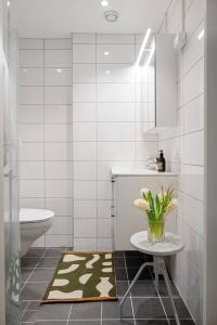 a bathroom with a toilet and a vase of flowers at Best place in Oslo city centre! Balcony & keyless. in Oslo