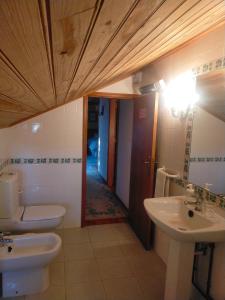 bagno con due servizi igienici, lavandino e corridoio di Quinta do Archino 18 a Lisbona