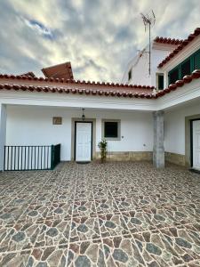 een wit huis met een betegelde binnenplaats ervoor bij A Casa Dos Avós in Penha Garcia