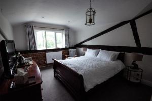 sypialnia z dużym łóżkiem i oknem w obiekcie High Barn w mieście Thursley