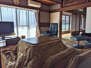 un soggiorno con divano, 2 sedie e TV di ステイ和屋Ooasa徳島で家族とのんびりできる和室宿 a Naruto