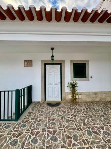 Habitación con puerta blanca y suelo de piedra. en A Casa Dos Avós, en Penha Garcia