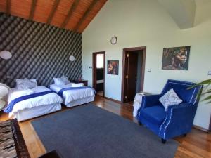 Florances Rest House في نيروبي: غرفة نوم بسريرين وكرسي ازرق