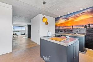 a kitchen with a island with a sunset painting on the wall at ROOFTOP Garden ACHT in Olpenitz