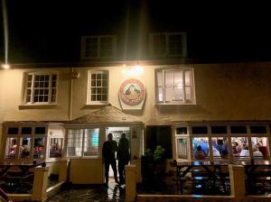 dos personas de pie fuera de un restaurante por la noche en Seaview Inn, en Falmouth