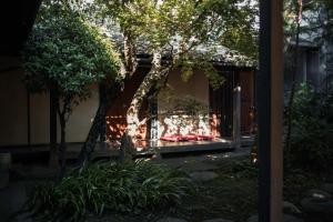 a house with a tree in the middle of a yard at Shirafuji in Suzaka