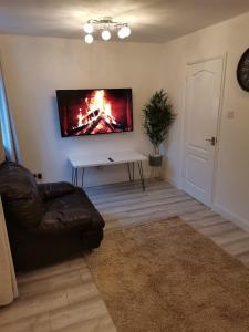 a living room with a fire on the wall at Newly Renovated Cosy 1 bed flat, 4 minutes walk to Town Centre, 3 minutes walk to the train station, Free parking, Modern, fresh and spacious living room, Netflix ready smart TV, Wifi in Wellingborough