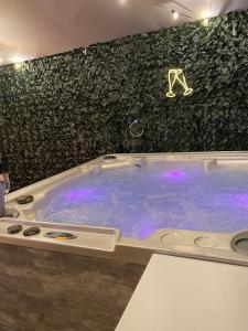uma banheira de hidromassagem com iluminação roxa num quarto em Luxury Urban Hideaway with private hot tub & Pole em Croydon