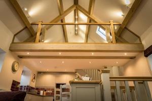 a room with aamed ceilings and a kitchen with at Cart House - Stunning Cottage - Axbridge in Axbridge