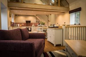 a living room with a couch and a kitchen at Cart House - Stunning Cottage - Axbridge in Axbridge