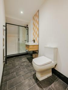 a bathroom with a toilet and a shower and a sink at Rise Duplex Apartments - Market Harborough in Market Harborough