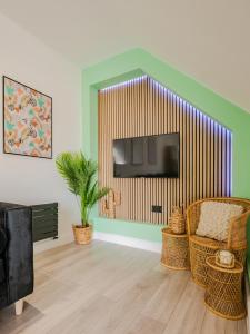 een woonkamer met een televisie en een stoel bij Rise Duplex Apartments - Market Harborough in Market Harborough