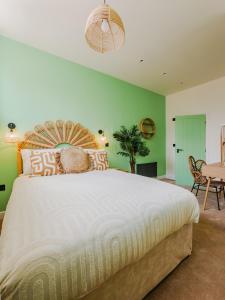 a bedroom with a large bed with green walls at Rise Duplex Apartments - Market Harborough in Market Harborough