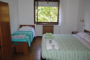 two beds in a room with a window and a bed sidx sidx sidx at Appartamento da Bruna e Manuela in Tenno