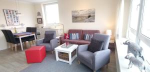 ein Wohnzimmer mit einer Couch und Stühlen und einem Tisch in der Unterkunft Wohnung Paul in Westerland