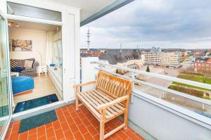 einen Balkon mit einer Holzbank und Stadtblick in der Unterkunft Wohnung Paul in Westerland