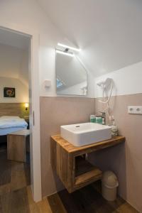 uma casa de banho com um lavatório branco e um espelho. em Roca Restaurant und Hotel em Bommersheim