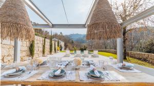 a dining table in a conservatory with a view at Casa da Cascata in Geres