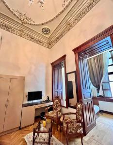 uma sala de estar com tecto e cadeiras em caixote em GARDEN İNN NİZAMİ HOTEL em Baku