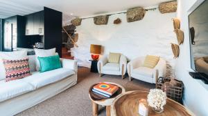a living room with two white couches and a table at Casa da Cascata in Geres