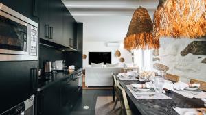 a kitchen with a dining table and a living room at Casa da Cascata in Geres