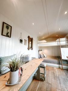Semi Detached Cottage Snowdonia with hot tub في Tal-y-Cafn: غرفة مع طاولة خشبية أمام سرير