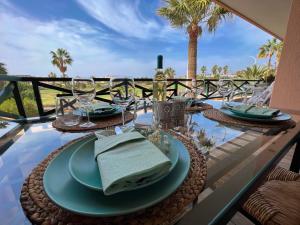 a table with plates and wine glasses on a balcony at Paz Ocean View, Air condition, Wifi, Heated pool in San Miguel de Abona