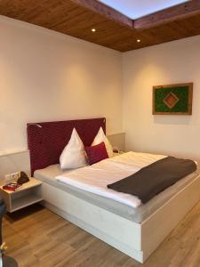 een slaapkamer met een groot bed met een rood hoofdeinde bij Luxus Suite zur Therme in Bad Griesbach +8 foto's