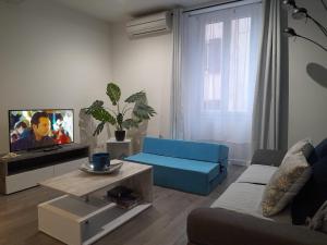 sala de estar con sofá azul y TV en Superbe loft 52 m2 où tout est accessible à pied en Port-Vendres