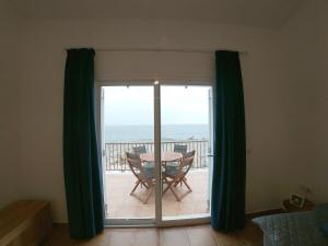 a room with a table and a view of the ocean at Piso en primera linea de mar - CA NA NÚRIA in Cala Blanca