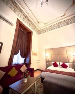 um quarto de hotel com uma cama e um sofá em GARDEN İNN NİZAMİ HOTEL em Baku