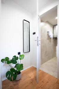 a bathroom with a mirror and a potted plant at Green Room in Zadar