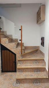 a set of stairs in a building with a wooden door at Casa preciosa con vistas in Granada