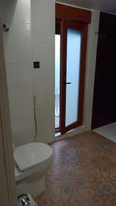 a bathroom with a toilet and a door with a window at Casa preciosa con vistas in Granada
