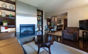 a living room with a fireplace and a table at Le Nouvel Hotel in Montréal