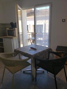 a table and two chairs in a room with a kitchen at Locmeze in Mèze +1 photo