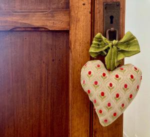 a heart ornament hanging on a door with a bow at Anita Bnb Rimini in Rimini